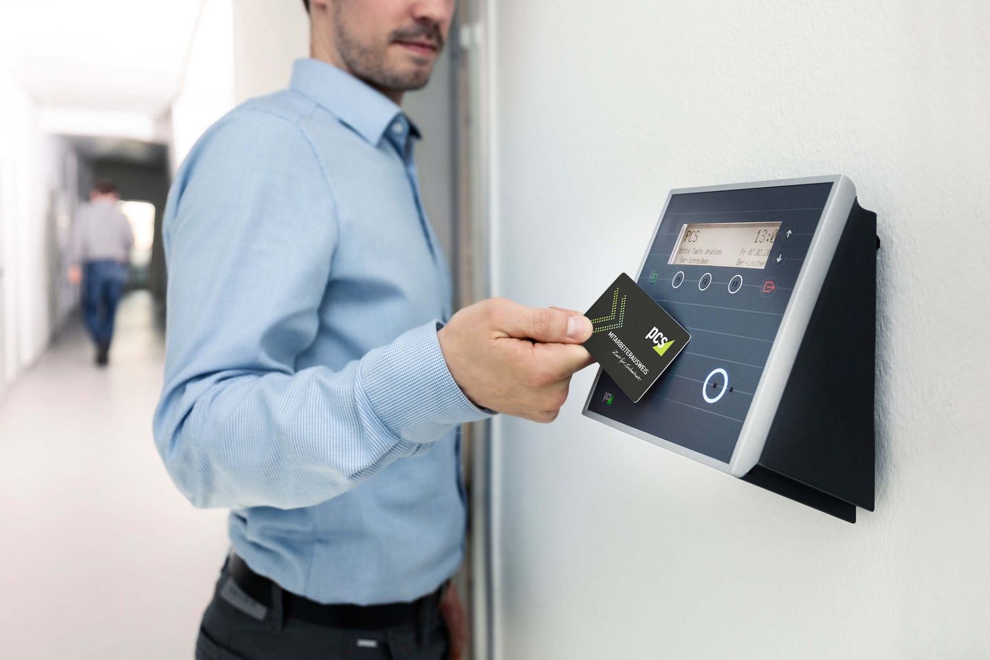 Professional presenting a contactless identification card at an access-control reader.
